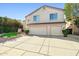 Inviting two-story home features a three-car garage and a well-maintained, charming front yard at 5291 W Angela Dr, Glendale, AZ 85308