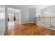 Bright hallway with hardwood floors and a view into another room with vaulted ceilings at 5291 W Angela Dr, Glendale, AZ 85308