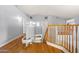 Bright hallway with wood floors and staircase featuring natural wood banister at 5291 W Angela Dr, Glendale, AZ 85308