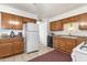 Well-lit kitchen with tile flooring, plenty of cabinet space, and white refrigerator at 5517 N 61St Ln, Glendale, AZ 85301