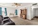 Open-concept living room with neutral carpet, desk, and a ceiling fan at 5517 N 61St Ln, Glendale, AZ 85301