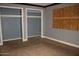 View of the bedroom with two closets and a boarded-up window at 6319 E Albany St, Mesa, AZ 85205
