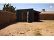Exterior view of backyard shed with open doors offering ample storage space next to brick fence at 6319 E Albany St, Mesa, AZ 85205