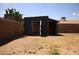 Exterior view of backyard shed with open doors offering ample storage space next to brick fence at 6319 E Albany St, Mesa, AZ 85205