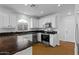 Well-lit kitchen featuring stainless steel appliances, white cabinetry, granite countertops, and hardwood floors at 7650 E Williams Dr # 1038, Scottsdale, AZ 85255