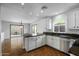 Kitchen with stainless steel appliances and hardwood floors adjacent to sunroom at 7650 E Williams Dr # 1038, Scottsdale, AZ 85255