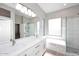 Modern bathroom features dual sinks, soaking tub, and glass-enclosed shower with marble tile at 7741 E Journey Ln, Scottsdale, AZ 85255