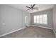 Carpeted bedroom with a ceiling fan, white trim, and window with white shutters at 7741 E Journey Ln, Scottsdale, AZ 85255