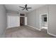 Carpeted bedroom featuring a ceiling fan, ensuite bathroom, and closet with white doors at 7741 E Journey Ln, Scottsdale, AZ 85255