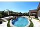 Beautiful backyard pool with rock features, lounge chairs, and outdoor patio at 7741 E Journey Ln, Scottsdale, AZ 85255