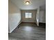 Cozy room with gray wood flooring, bright window, and white trim at 8427 W Glendale Ave # 31, Glendale, AZ 85305