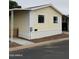 Manufactured home with yellow siding, white trim, and a small fence at 8427 W Glendale Ave # 31, Glendale, AZ 85305