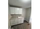 Bright laundry area with white cabinetry, granite countertops and vinyl flooring at 8427 W Glendale Ave # 31, Glendale, AZ 85305