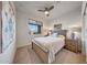 Inviting bedroom showcasing a comfortable bed, ceiling fan, and a window with outdoor views, offering tranquility at 8490 S 165Th Dr, Goodyear, AZ 85338