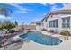 A pristine pool is surrounded by desert landscaping and a blue sky at 877 E La Costa Pl, Chandler, AZ 85249