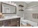 Bathroom with single sink vanity, dark cabinets, open shelving and shower with glass doors at 877 E La Costa Pl, Chandler, AZ 85249