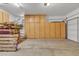 Spacious garage featuring built in cabinets with shelving, and a roll up garage door at 877 E La Costa Pl, Chandler, AZ 85249