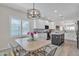 Open kitchen and dining area featuring an island, white cabinets, and modern lighting at 877 E La Costa Pl, Chandler, AZ 85249