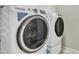 Modern white front load washer and dryer with smart features in tiled laundry room at 877 E La Costa Pl, Chandler, AZ 85249