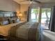 Relaxing bedroom featuring a large bed, bedside lamp, and sliding glass doors to the outdoor patio at 9734 W Kerry Ln, Peoria, AZ 85382