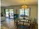 Dining area featuring modern light fixture, glass table, and access to the backyard patio at 9734 W Kerry Ln, Peoria, AZ 85382