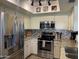 Modern kitchen features stainless appliances, tile backsplash, granite counters and ample lighting at 9734 W Kerry Ln, Peoria, AZ 85382