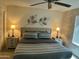 Cozy main bedroom featuring a queen-size bed, nightstands with lamps, and decorative leaf accent on the wall at 9734 W Kerry Ln, Peoria, AZ 85382