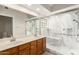 Bathroom featuring a double vanity, soaking tub and a glass enclosed shower with white marble surround at 10017 E Mountain View Road -- # 1045, Scottsdale, AZ 85258