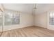 Bright bedroom with wood-look floors, a ceiling fan, and large windows with blinds at 10017 E Mountain View Road -- # 1045, Scottsdale, AZ 85258