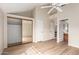 Open bedroom with wood-look floors, and a closet with mirrored doors adjacent to a private bathroom at 10017 E Mountain View Road -- # 1045, Scottsdale, AZ 85258