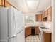 Well-lit kitchen with tile countertops, wood cabinets, and modern appliances at 10017 E Mountain View Road -- # 1045, Scottsdale, AZ 85258