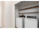 Laundry room equipped with a full-size washer, dryer and wood shelving at 10017 E Mountain View Road -- # 1045, Scottsdale, AZ 85258