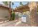 Gated community pool area with a wooden pergola and lush palm trees creating a private oasis at 10017 E Mountain View Road -- # 1045, Scottsdale, AZ 85258