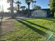 Well-maintained exterior with a green lawn, swimming pool, and mature palm trees at 10249 N 58Th Pl, Paradise Valley, AZ 85253