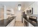 Updated kitchen with stainless steel appliances, subway tile backsplash, and black countertops at 1118 N Granite Reef Rd, Scottsdale, AZ 85257