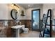 Elegant bathroom featuring a pedestal sink, accent wall, and textured glass door at 11319 E Elmhurst Dr, Chandler, AZ 85249