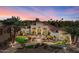 Elegant home showcasing desert landscaping, a circular driveway, and a red tile roof under a vibrant sunset sky at 11319 E Elmhurst Dr, Chandler, AZ 85249