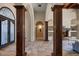 Interior view showcasing tile flooring, dark wood columns, an ornate fireplace, and a decorative front door at 11319 E Elmhurst Dr, Chandler, AZ 85249