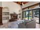Inviting living space with a cozy fireplace, tiled floors, and an expansive view of the backyard pool area at 11319 E Elmhurst Dr, Chandler, AZ 85249