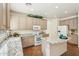 Well-lit kitchen with granite counters, white appliances, island and tiled floors at 11564 W Harrison St, Avondale, AZ 85323