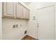 Functional laundry room features ample cabinet space, utility connections, and easy access to the door at 11564 W Harrison St, Avondale, AZ 85323