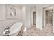 Bathroom featuring a soaking tub, decorative mirror, and access to a walk-in shower at 12 E Oakwood Hills Dr, Chandler, AZ 85248