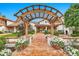 Charming home featuring a wooden pergola entry, brick walkway, and beautifully landscaped garden, offering inviting curb appeal at 12 E Oakwood Hills Dr, Chandler, AZ 85248