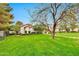 Lush green lawn and landscaped yard with mature trees in front of a luxurious home under a blue sky at 12 E Oakwood Hills Dr, Chandler, AZ 85248