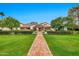 Beautiful home with lush lawn and mature trees, features a pergola entry and brick walkway leading to the inviting front door at 12 E Oakwood Hills Dr, Chandler, AZ 85248