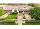 Expansive home with a lush lawn, manicured landscaping, and a charming bridge leading to the main entrance at 12 E Oakwood Hills Dr, Chandler, AZ 85248