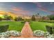 Expansive property featuring a brick path that runs through a beautifully manicured lawn with mature trees, hedges, and flowerbeds at 12 E Oakwood Hills Dr, Chandler, AZ 85248