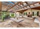 Outdoor living space with stone floors, pergola, fireplace, outdoor grill, and a rustic wood table at 12 E Oakwood Hills Dr, Chandler, AZ 85248