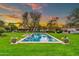Stunning backyard features a rectangular pool, surrounded by a lush lawn and mature trees, creating a private oasis at 12 E Oakwood Hills Dr, Chandler, AZ 85248