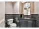 Elegant powder room features black brick accent wall, patterned floor tiles and sophisticated lighting fixture at 12 E Oakwood Hills Dr, Chandler, AZ 85248